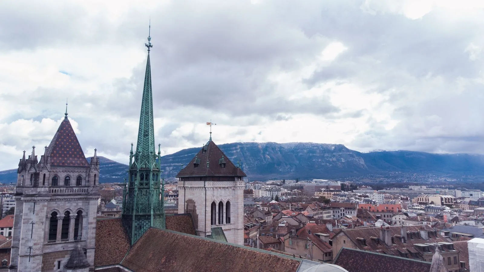 Les tours et la flèche verte de la cathédrale Saint-Pierre au-dessus des toits de Genève